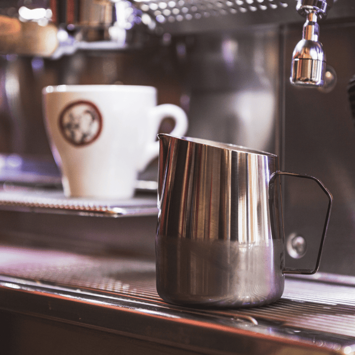 professional barista milk pitcher at a coffee shop